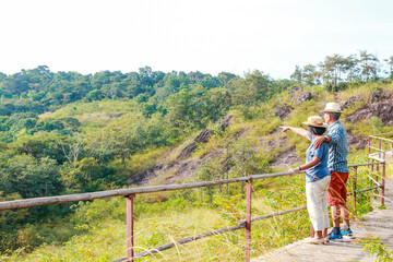 Fototapeta na wymiar Asian elderly couple enjoying traveling Standing on the mountain looking at the beautiful natural scenery. Tourism concept. healthy. Happy living in retirement. Copy space