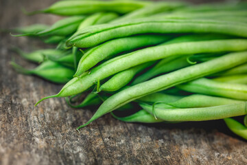Bunch of organically grown 'Maxibel' French filet green beans harvested from a home garden on a rustic wooden table