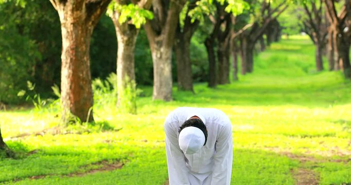 Religious muslim man traditional kandura praying outdoor at quiet nature environment sun beams.