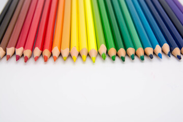 Group of colored pencils and crayons on white background. Text space.