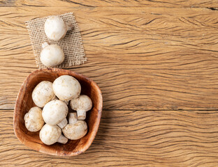 Paris mushrooms in a bowl over wooden table with copy space