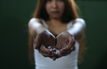 Depresssed woman holding many pills in hand,selective focus on hand.