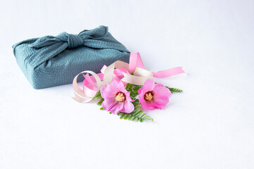 Obraz na płótnie Canvas 風呂敷包みとピンクの芙蓉の花とリボン（白バック）
