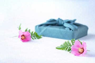 Obraz na płótnie Canvas 風呂敷包みとピンクの芙蓉の花（白バック）