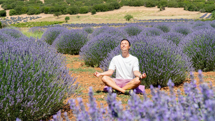 A man conducts meditation in nature in a lavender field