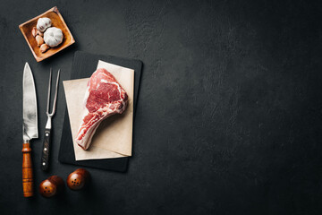 Raw tomahawk or cowboy steak cooking background woth copy space