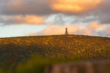 Poland, the Sudetes Mountains, mountain landscape in the Snieznik Massif, an observation tower under construction on top of the Snieznik Mountain. The summit is illuminated by the setting sun.