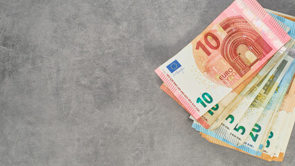 stack of euro banknotes on gray background, top view of euro banknotes of different denominations,...