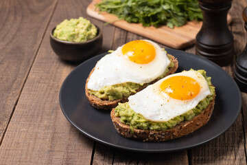 Two avocado open sandwiches with egg. Keto and diet concept. Healthy toast food for breakfast.
