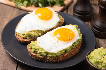 Two avocado open sandwiches with egg. Keto and diet concept. Healthy toast food for breakfast.