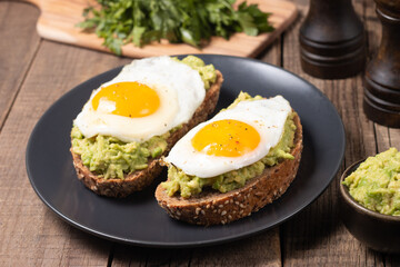 Two avocado open sandwiches with egg. Keto and diet concept. Healthy toast food for breakfast.