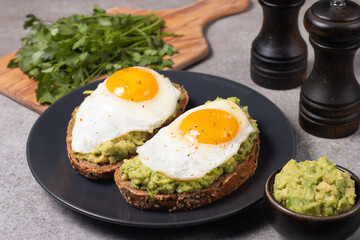 Two avocado open sandwiches with egg. Keto and diet concept. Healthy toast food for breakfast.
