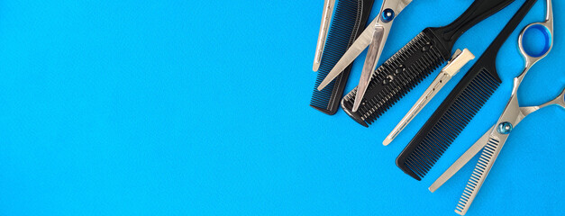 Comb scissors and accessories for hairdressers on blue background