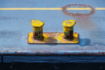 Zwei gelbe Stahl-Poller in einem Hafen am Kai / Schiffsanlegestelle (Bollard harbour - mooring)