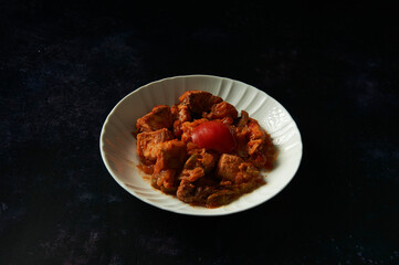 tuna dish with tomato on dark background