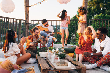 Hippie friends have a party on the roof. - 525141462