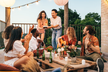 Friends celebrate a birthday at the rooftop party.