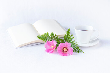 ピンクの美しい芙蓉の花のブーケと見開きの本とコーヒー（白バック）