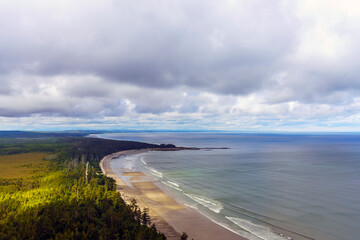Panoramic aerial view of endless, almost deserted sandy BC beaches at low tide on a cloudy summer day.