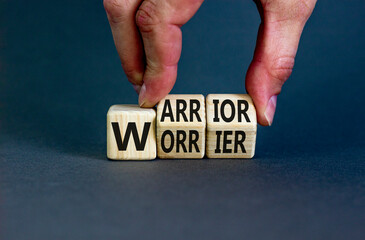 Be warrior not worrier symbol. Concept words Warrior and Worrier on wooden cubes. Businessman hand. Beautiful grey table grey background. Business and Be warrior not worrier concept. Copy space.