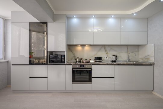 Interior of modern trendy white kitchen, front view