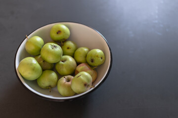 green homemade apples on table left on dark table