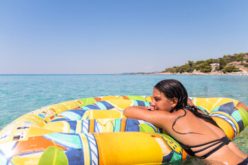 Idyllic summer vacation..A beautiful teenage girl in a bikini relaxes in a sea lagoon on an air...
