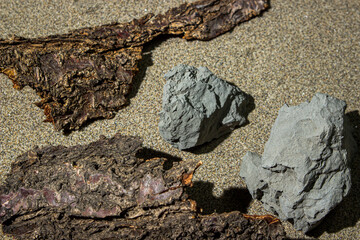 Stones and tree bark on a background of sand. Natural background for the image. natural materials