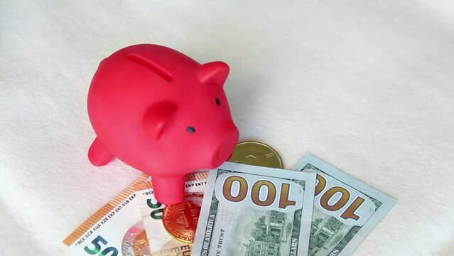 Piggy bank among dollar and euro banknotes. Cryptocurrency coins are visible. Multicurrency savings. Risk while saving money. On a white background.