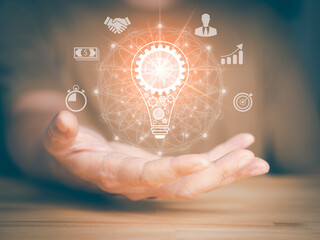 Hand hold light bulb, gears icon and brain inside the light bulb. Money, connection, chart, target sign, times and people icon. Idea of ​​inspiration online technology and innovation idea concept.
