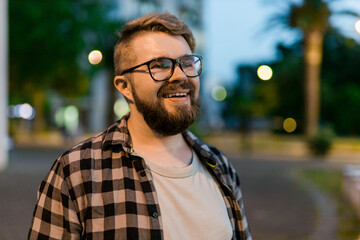 Portrait of man standing in evening city street with copy space and place for text. Confident happy guy. Close-up portrait