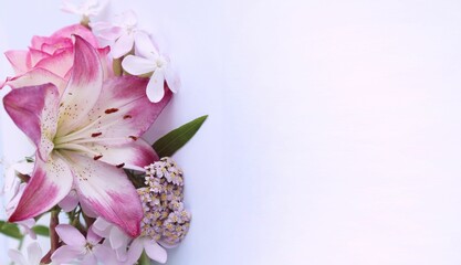 Delicate pink lilies and roses on a white background. Festive flower arrangement. Background for a greeting card.