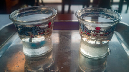 Asian glasses decorated with dragons, filled with sake