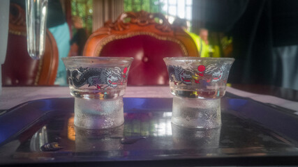 Asian glasses decorated with dragons, filled with sake