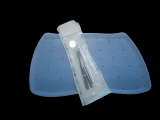 Dentist accessories, sterilized and packaged on a blue tray, all on a black background