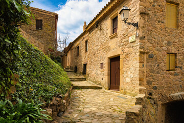 Fototapeta na wymiar View of one of the streets of the historic center of the castle of Tossa adorned with plants, Costa Brava, Catalonia Spain
