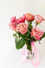 Beautiful bright pink-red roses, flowers in a vase, side view, vertical photo. Flowers for the holiday.