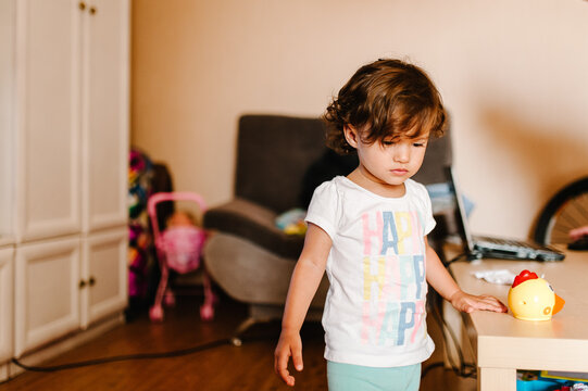 Portrait of a pretty, cute, toddler, girl, adorable baby playing toys indoors, little child play game having fun moving on the floor in a room at home or kindergarten.