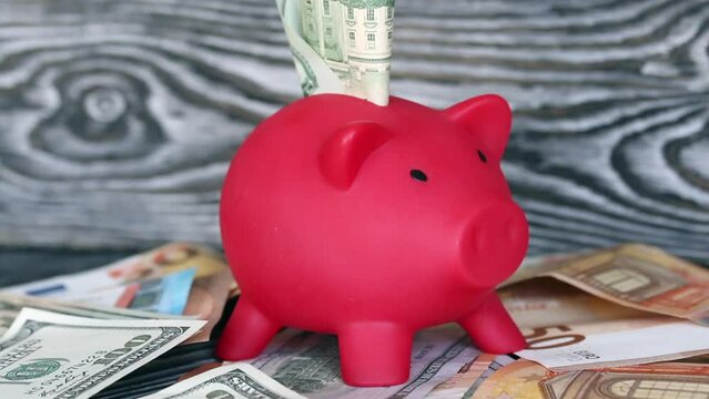 Piggy bank on dollar and euro banknotes. Next to the dice. Multicurrency savings. Risk while saving money._