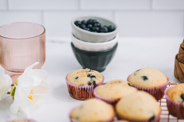 Homemade blueberry muffins baked to perfection on cooling rack in modern white marble kitchen.