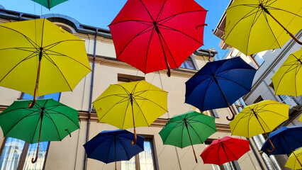 multi color umbrellas as street outdoor decoration, bright blue sky background 