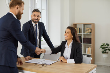Smiling diverse businesspeople shake hands get acquainted greeting at office meeting. Happy business partners or clients handshake close deal or make agreement after successful negotiation.