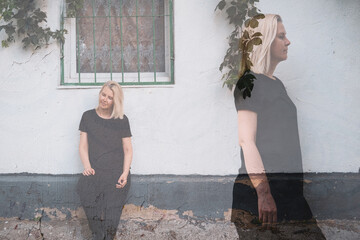 Multiple exposure double portrait of a woman against  white wall. Doubts, split personality, psychological help, difficult period in life