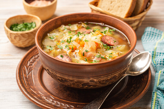 Polish sauerkraut soup Kapusniak in bowl on wooden background