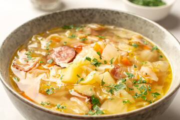 Polish sauerkraut soup Kapusniak in bowl on concrete background