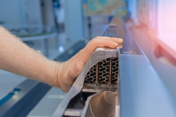 Man engineer hand holding fragment fuel uranium or thorium rod element of nuclear reactor water. Peaceful atom energy concept © Parilov