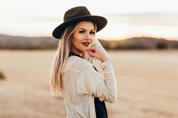 Portrait of beautiful woman wearing fedora hat outdoors