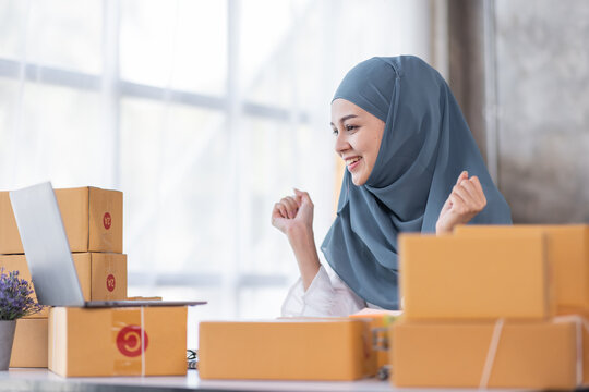 Muslim Young Asian business woman startup sme small business entrepreneur SME distribution warehouse with parcel mail box. Muslim girl SME Online marketing and product packaging and delivery service.
