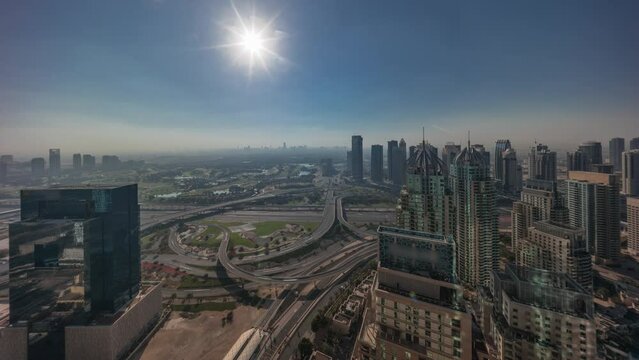 Sunrise over Dubai marina and JLT skyscrapers along Sheikh Zayed Road aerial morning timelapse. Residential and office buildings from above. Orange sky above golf course