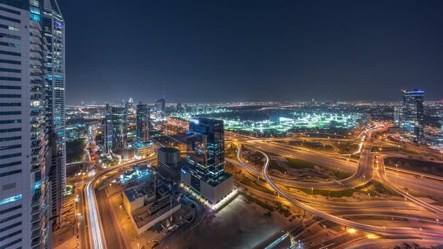 Aerial panoramic view of media city and al barsha heights district area day to night transition timelapse from Dubai marina. Towers and skyscrapers with traffic on a highway from above
